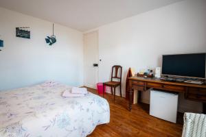 a bedroom with a bed and a desk with a television at Chambre privative Dives Cabourg in Dives-sur-Mer