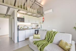 a living room with a couch and a kitchen at Olive Studios in Campo de Arca