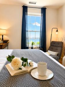 a room with a bed with a book and a cup of coffee at Fox Point Landing Residences in Providence