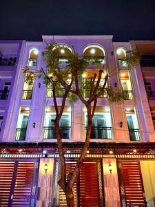 a building with a palm tree in front of it at Cưng Homestay SG in Ho Chi Minh City