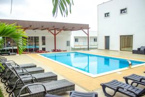 a pool with chaise lounge chairs and a swimming pool at Hotel Santos Silva in São Tomé