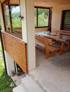 a porch of a house with a table and a bench at Planinska kuća Arbinje in Dojkinci