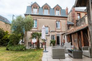 a patio with an umbrella in front of a building at Chambre privative Dives Cabourg in Dives-sur-Mer