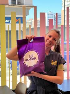 a woman is holding a purple bag at Wostel The Comfort Hostel in Málaga +43 photos