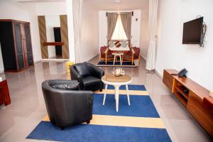 a living room with a black leather chair and a table at Tulivu Resort in Kituoni
