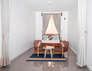 a living room with two chairs and a table at Tulivu Resort in Kituoni