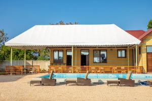a house with a pool and chairs in front of it at Tulivu Resort in Kituoni
