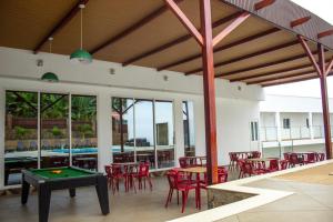 a patio with a pool table and red chairs at Hotel Santos Silva in São Tomé