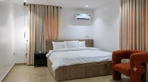 a bedroom with a large bed and a chair at Three bedroom apartment Magodo GRA in Magodo
