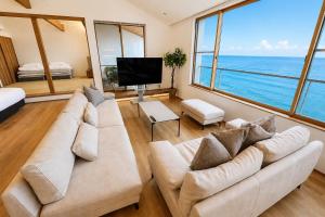 a living room with a couch and a television at Villa JacoO 2 in Sanuki