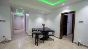 a dining room with a table and chairs and a green light at Three bedroom apartment Magodo GRA in Magodo