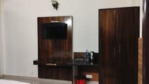 a room with a entertainment center with a flat screen tv at Mcleodganj Mountain View Royal india-cheapest hotel in McLeod Ganj- Near Dalai Lama temple 100m-best hotel on Temple Road! in Dharamshala