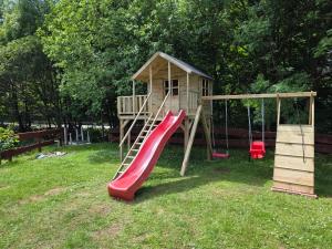 a playground with a slide and a play house at Krokusowa Przystań-SPA,Restauracja i Noclegi w Górach Sowich in Rzeczka