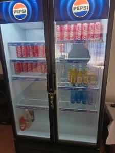a refrigerator filled with drinks and soda at Fourways guesthouse & spa in Fourways