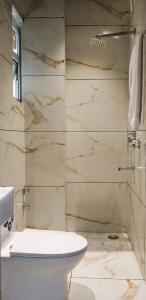 a bathroom with a white toilet and a shower at The Glam By Sandane Homes in Greater Noida +92 photos