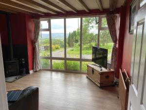 a living room with a tv and a large window at The Cottage in Middlesbrough