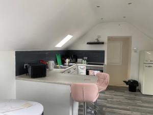 a kitchen with a counter and a pink chair at The Cottage in Middlesbrough