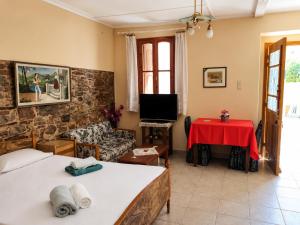 a living room with two beds and a red table at Elegant Studio in Chios near the Beach and Port in Chios