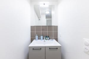 a bathroom with a white sink and a mirror at 205 - L'Obsidienne - Wifi in Achères