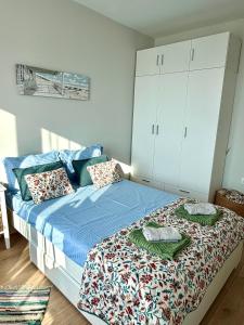 a bedroom with a bed with blue sheets and white cabinets at Skyline 11B Apartment - Sea View,Pools & SPA in Varna City