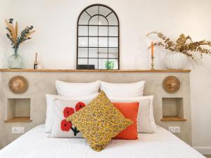 a bedroom with a white bed with red and yellow pillows at Chambres d'hôte Casprese in Altiani