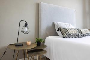 a bedroom with a bed with a lamp and two stools at 301 - L'Obsidienne - Wifi in Achères +16 photos