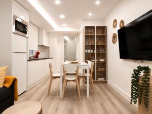 a kitchen and living room with a table and chairs at Sisargas Playa in Malpica