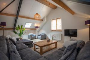 a living room with a couch and a coffee table at Boerderij appartement De Casterie in Bornerbroek