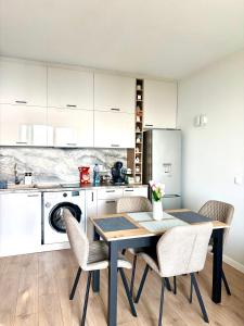 a kitchen with a table and chairs in a kitchen at Skyline 11B Apartment - Sea View,Pools & SPA in Varna City