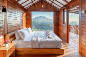 a bed in a room with a view of a mountain at Kamani Cabin by Moria in Kubupenlokan