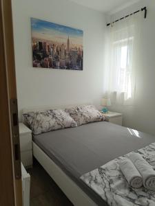 a bedroom with a bed and a picture on the wall at Apartment Domagoj, Novalja,with 3 air conditioning units in Novalja