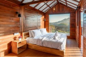 a bedroom with a bed and a large window at Kamani Cabin by Moria in Kubupenlokan