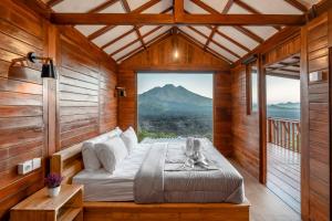 a bed in a wooden room with a large window at Kamani Cabin by Moria in Kubupenlokan +16 photos