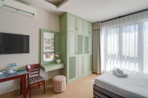 a bedroom with a bed and a desk and a tv at LangX Heaven Hotel & Apartment in Danang