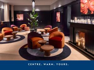 a waiting room with chairs and a fireplace at Falkensteiner Boutique Hotel Prague in Prague +54 photos