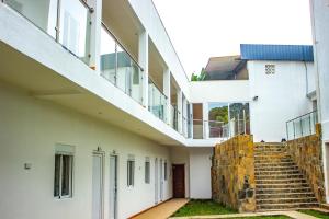 an external view of a white building with stairs at Hotel Santos Silva in São Tomé