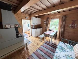 ein Wohnzimmer mit einem Tisch in einer Blockhütte in der Unterkunft Metsäpirtti in Kolinkylä