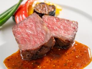 two pieces of meat on a plate with sauce at Wan Wan Paradise Yatsugatake in Hokuto