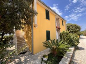 a yellow building with a door and some plants at Apartments Vicelić in Lovište