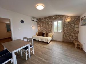 a bedroom with a bed and a stone wall at Apartments Vicelić in Lovište