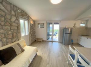 a living room with a couch and a stone wall at Apartments Vicelić in Lovište