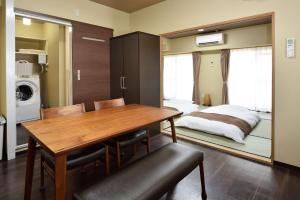 a dining room with a table and a bed at Wallaby House in Kawaguchi