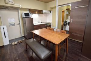 a small kitchen with a wooden table and chairs at Wallaby House in Kawaguchi