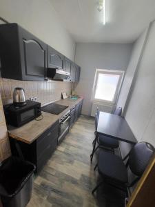 a kitchen with black cabinets and a table and chairs at Aparthotel Boardinghouse BRACK mit Parkplatz Küche WIFI in Bielefeld