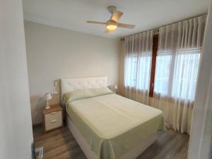 a bedroom with a bed and a ceiling fan at Apartaments Lamoga - Sandi in Torredembarra