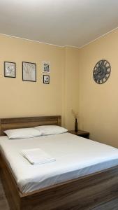 a bedroom with a bed with a clock on the wall at Aqua Batumi 46 in Batumi +10 photos