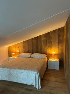 a bedroom with a large bed with two night stands at Lodge Valchiavenna in Verceia +19 photos