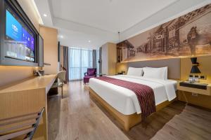 a hotel room with a large bed and a flat screen tv at Mercure Chengdu Downtown Hotel in Chengdu +32 photos