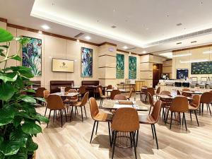 ein Restaurant mit Tischen und Stühlen in einem Raum in der Unterkunft Royal Dragon Hotel in Macau
