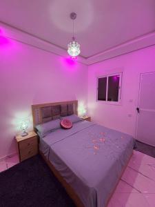 a bedroom with a bed with pink lights on it at Martil in Martil